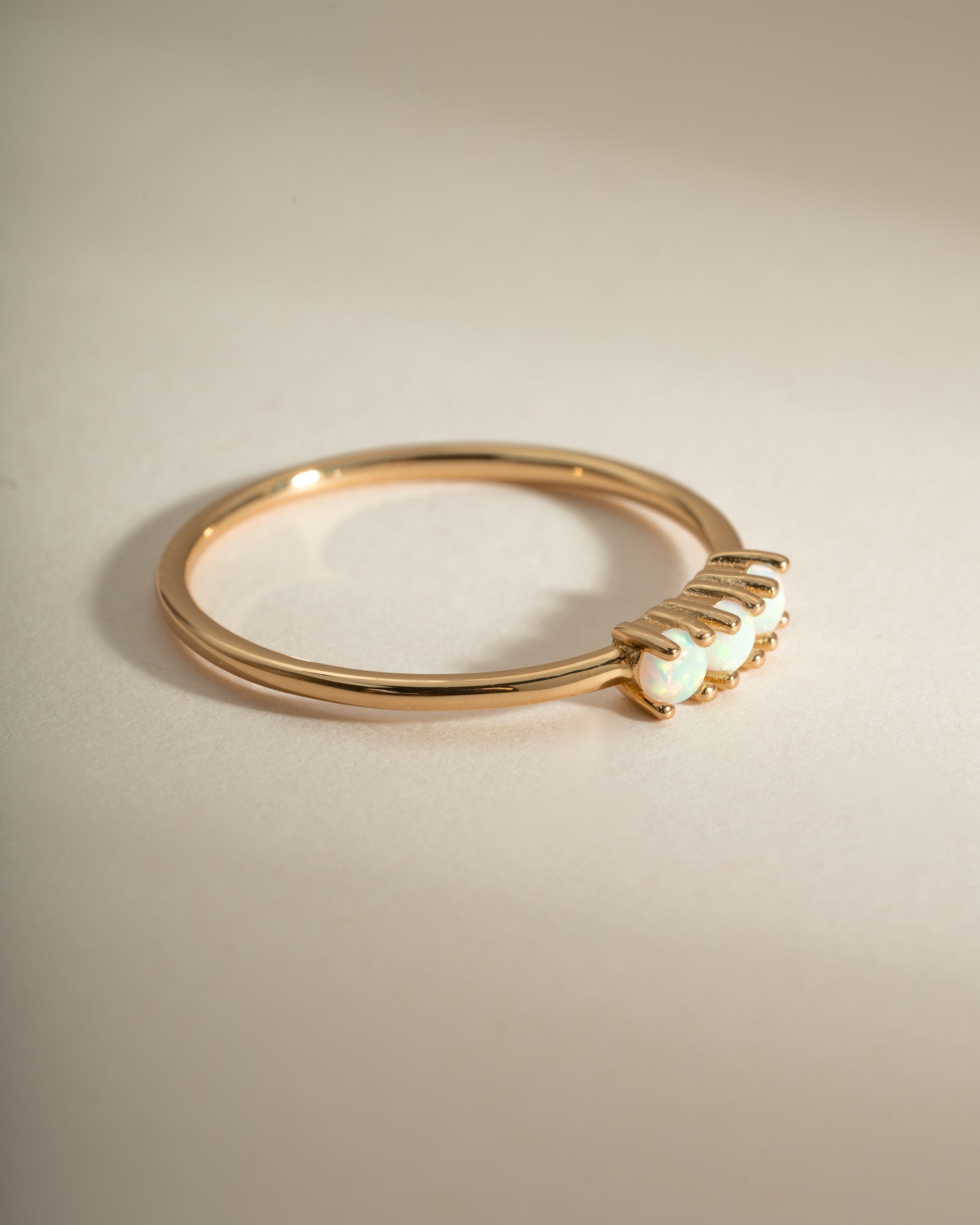 Gold 3-stone opal ring from Sami Jewels, side view showing vibrant multi-colored opal gemstones and elegant band detail.