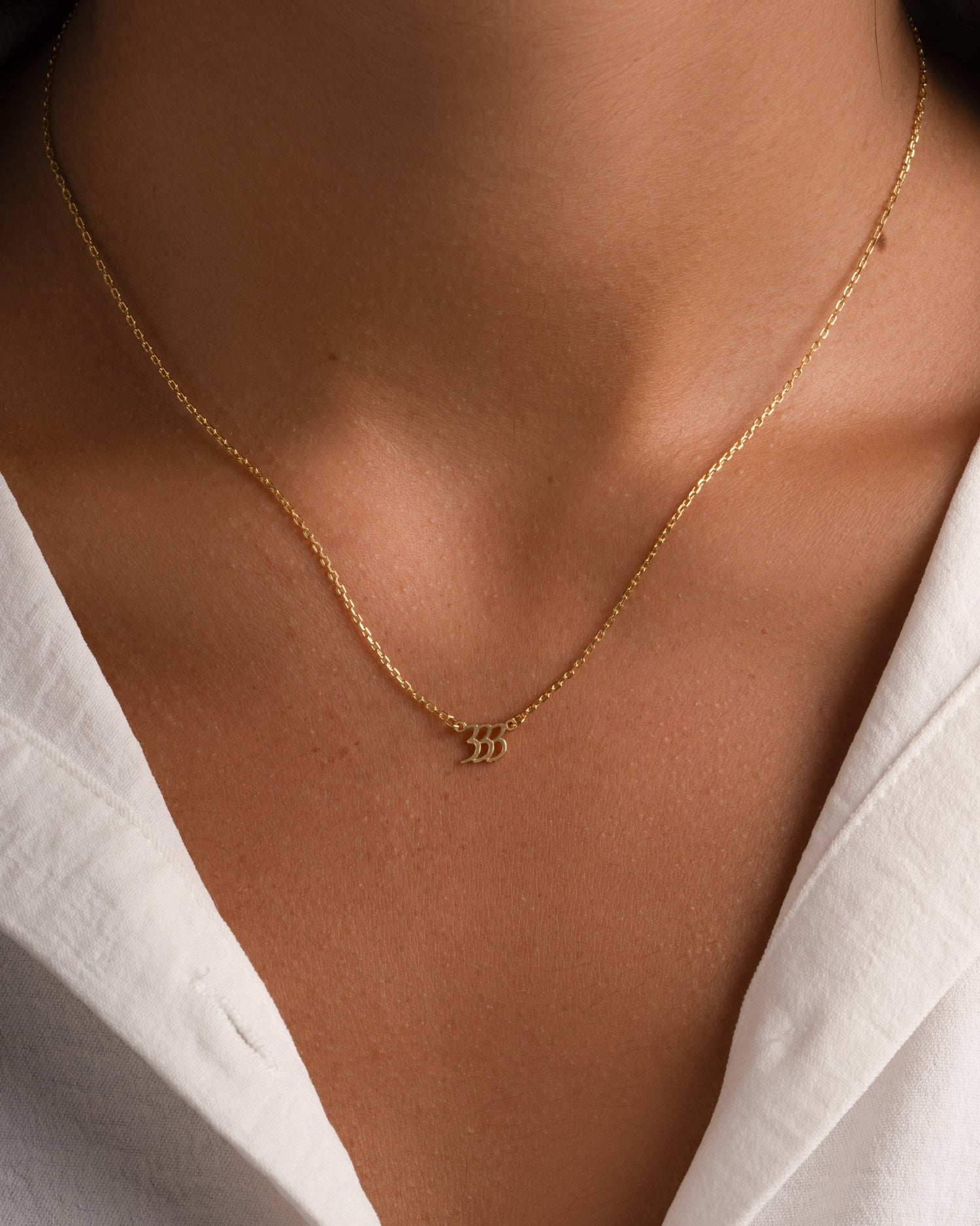 Gold angel number necklace from Sami Jewels featuring the number 333, designed as a stylish and meaningful jewelry piece.