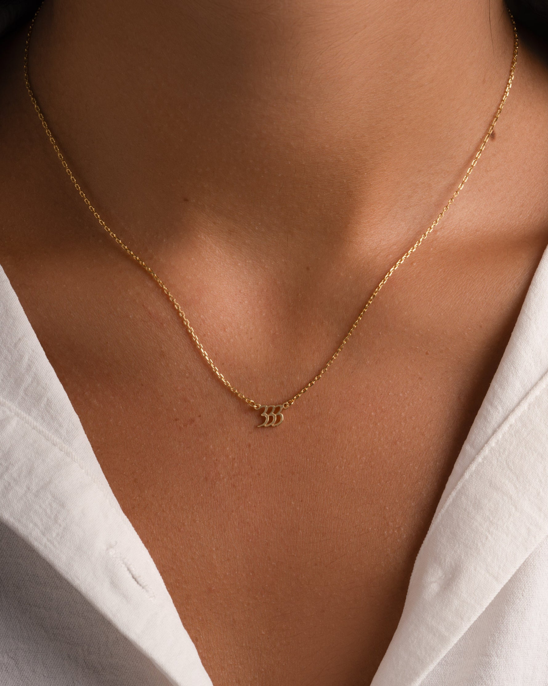 Gold angel number necklace from Sami Jewels featuring the number 333, designed as a stylish and meaningful jewelry piece.