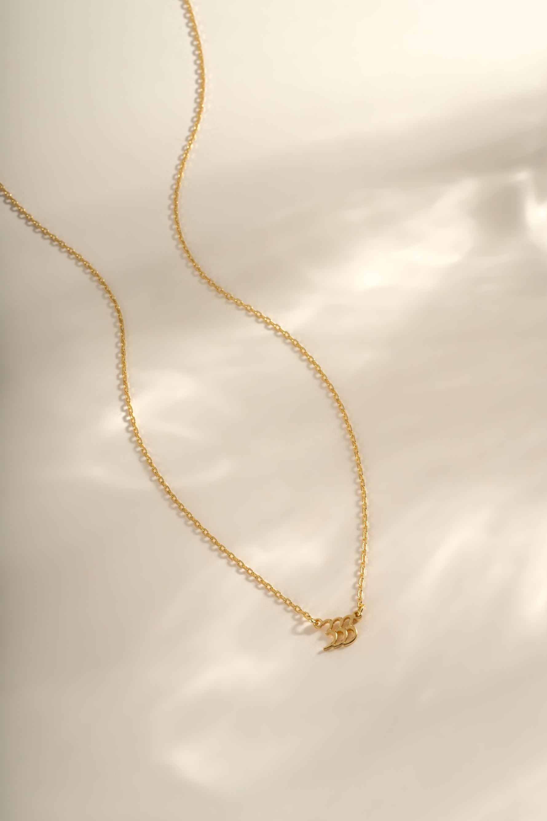 Gold angel number necklace from Sami Jewels featuring the number 333 on a delicate chain.