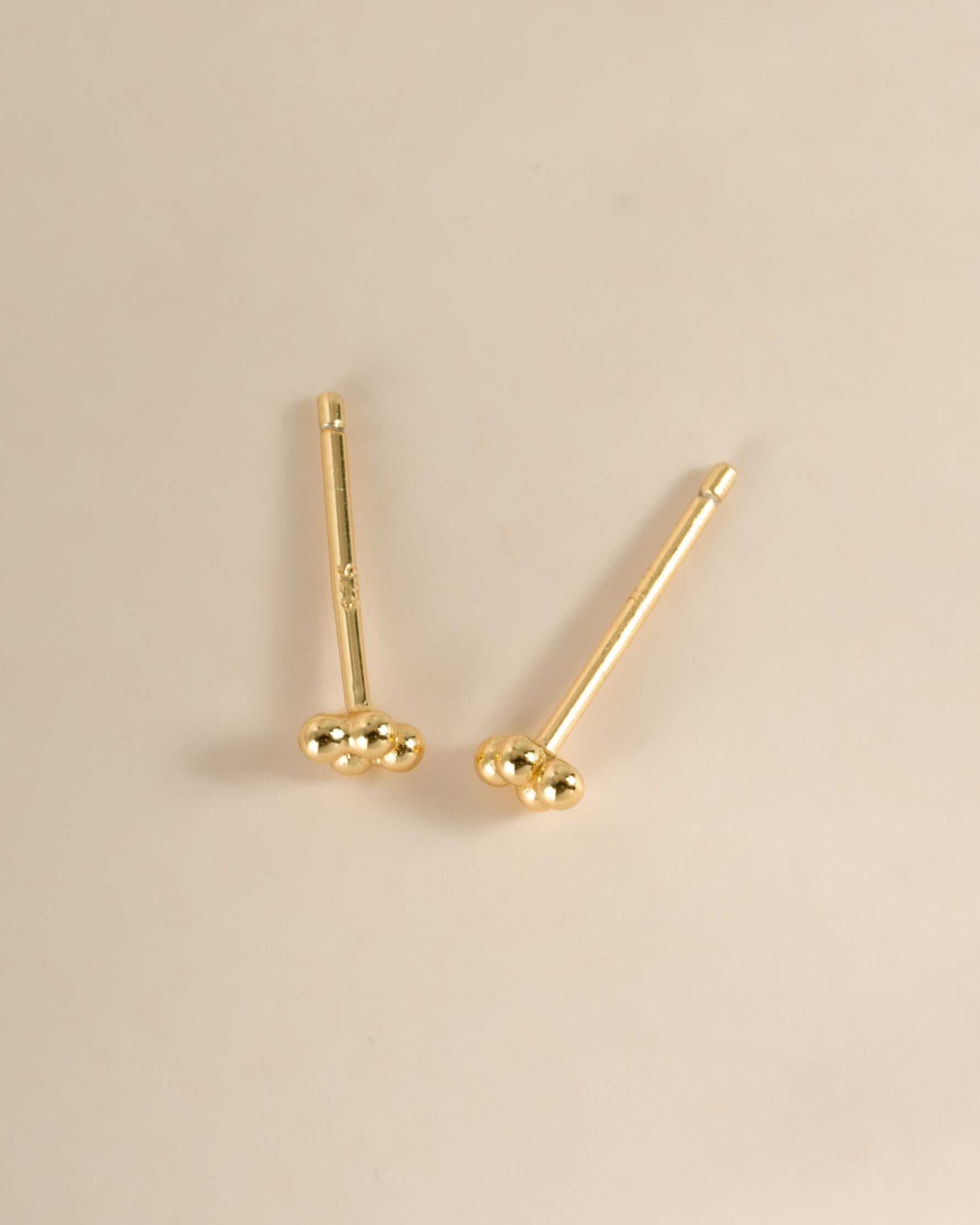 Gold 4-ball stud earrings by Sami Jewels, top view showing small round ball designs on each earring.