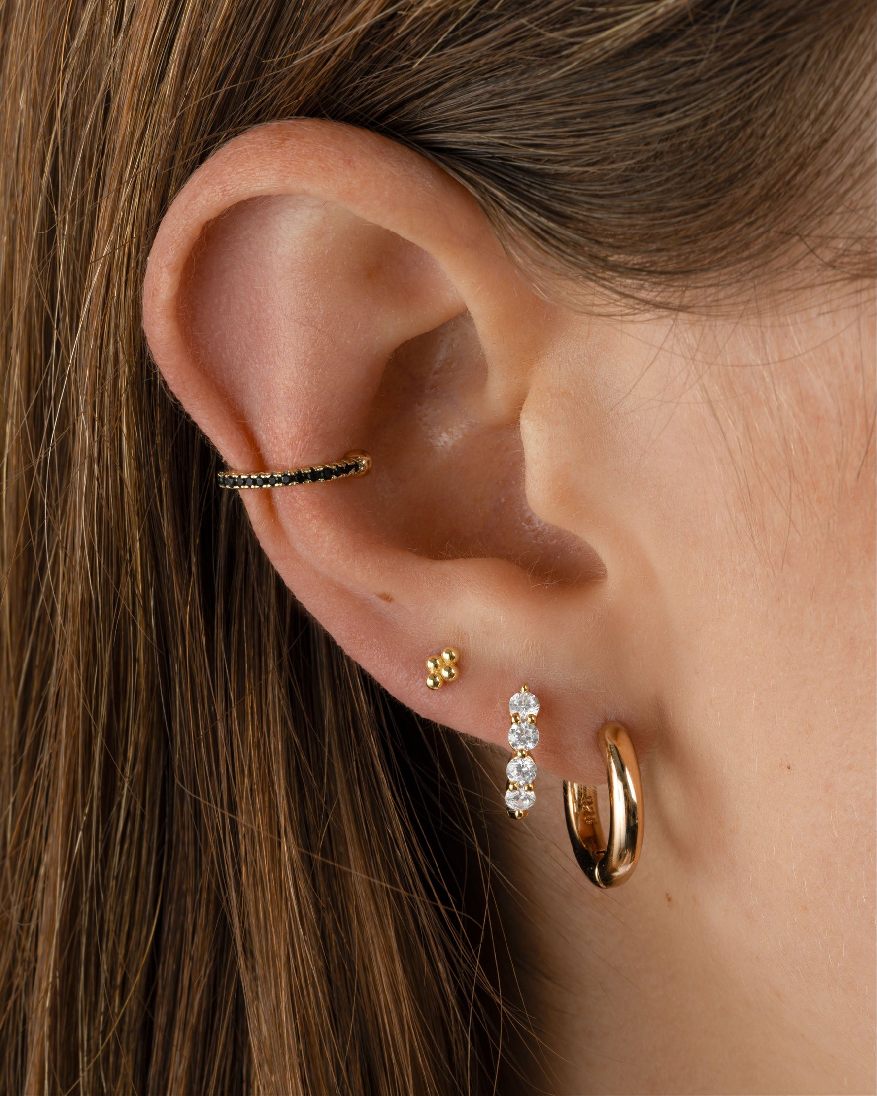 Gold 4-ball stud earrings by Sami Jewels styled on a model, showcasing simple and elegant jewelry design.
