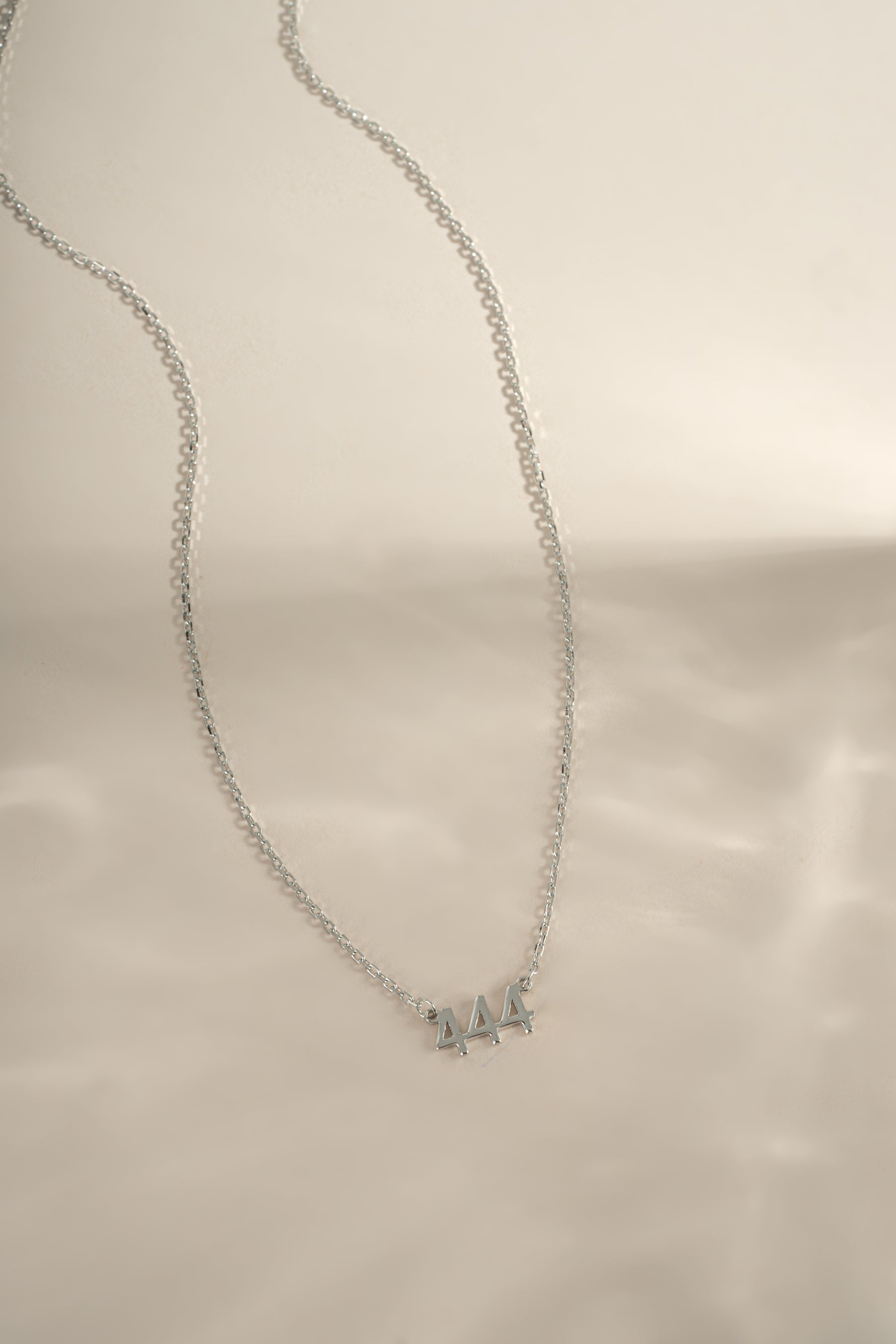 Sterling silver Angel Number 444 necklace by Sami Jewels featuring a delicate chain and engraved numerals.