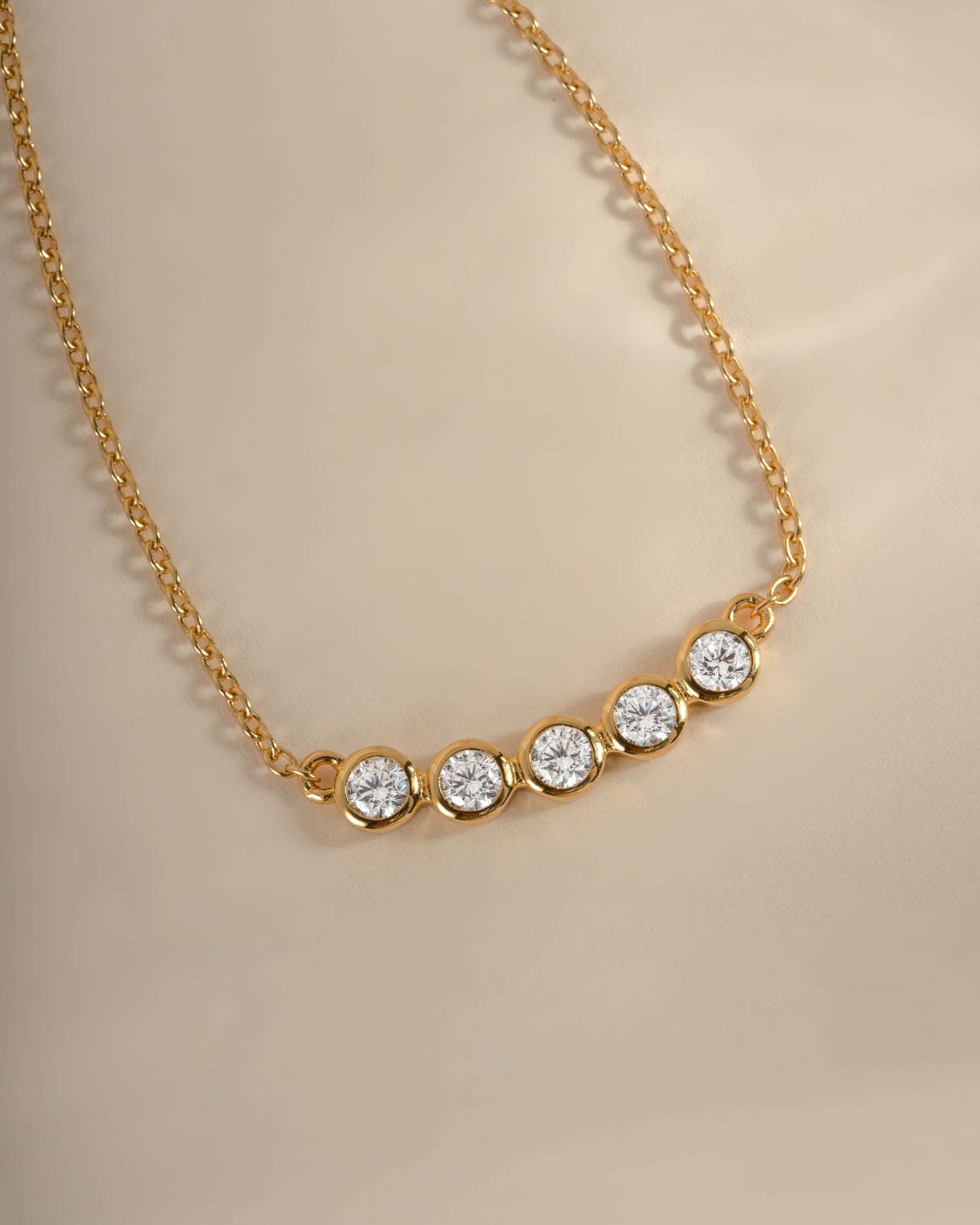 Close-up of Sami Jewels five-stone diamond gold bar necklace showcasing sparkling gemstones and sleek jewelry design.