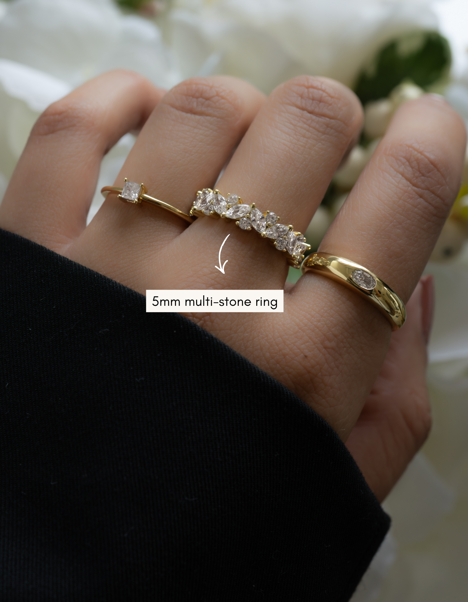 gold 5mm multi-stone diamond band on womens hand with stackable rings