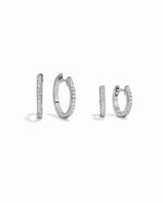 Close-up of 925 sterling silver pave diamond huggie earrings, comparing sizes
