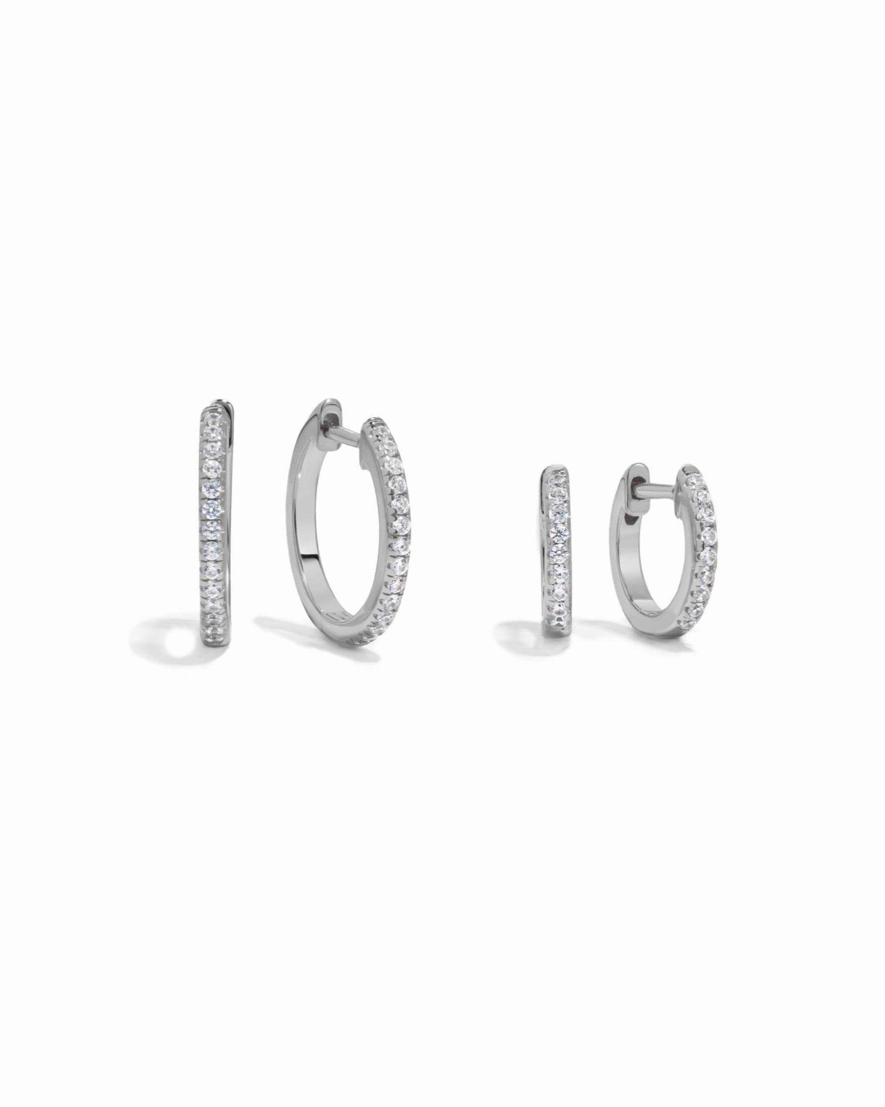 Close-up of 925 sterling silver pave diamond huggie earrings, comparing sizes