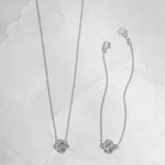 close up photo of silver four leaf clover necklace that can be matched with the clover bracelet. 