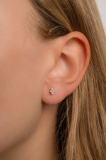 Model wearing sterling silver diamond shaped studs with 4 diamond stones. 