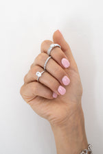 Sterling silver rings stacked on model.