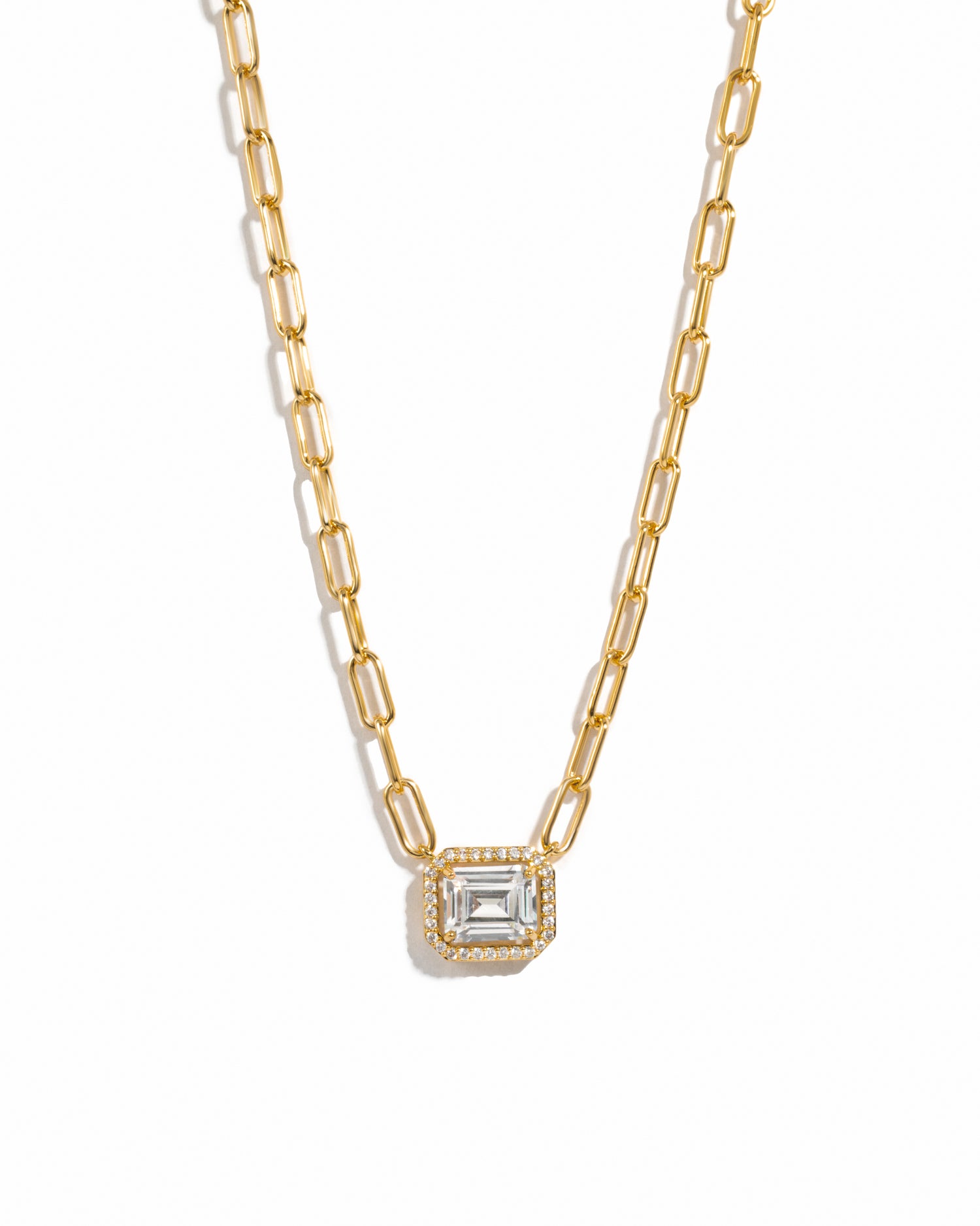 Gold paperclip chain necklace with a diamond pendant on a white background