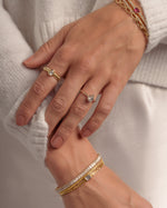 Model wearing stacked fold rings, bracelets, with diamonds.