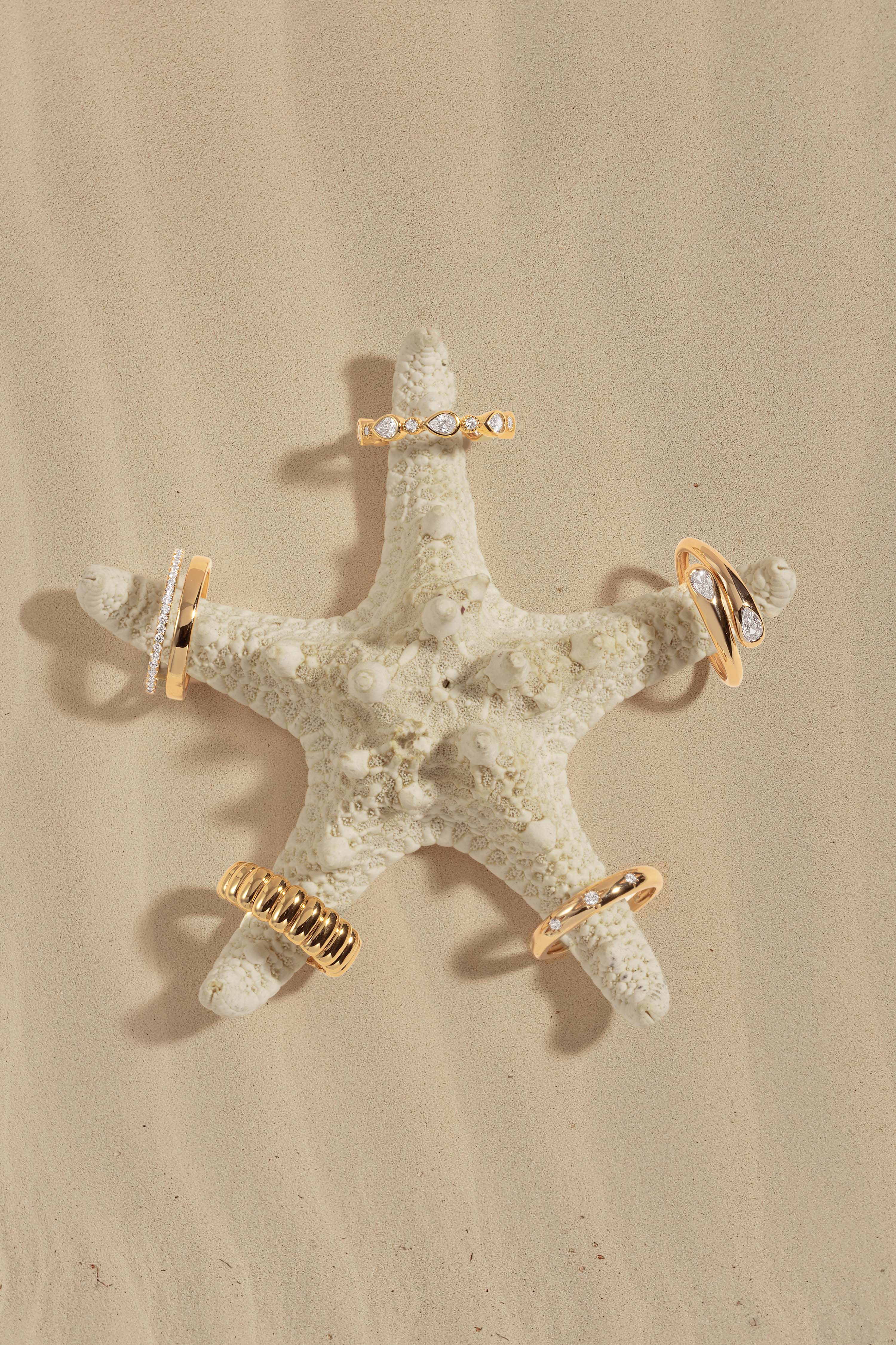Starfish with gold and crystal earrings on a beige background