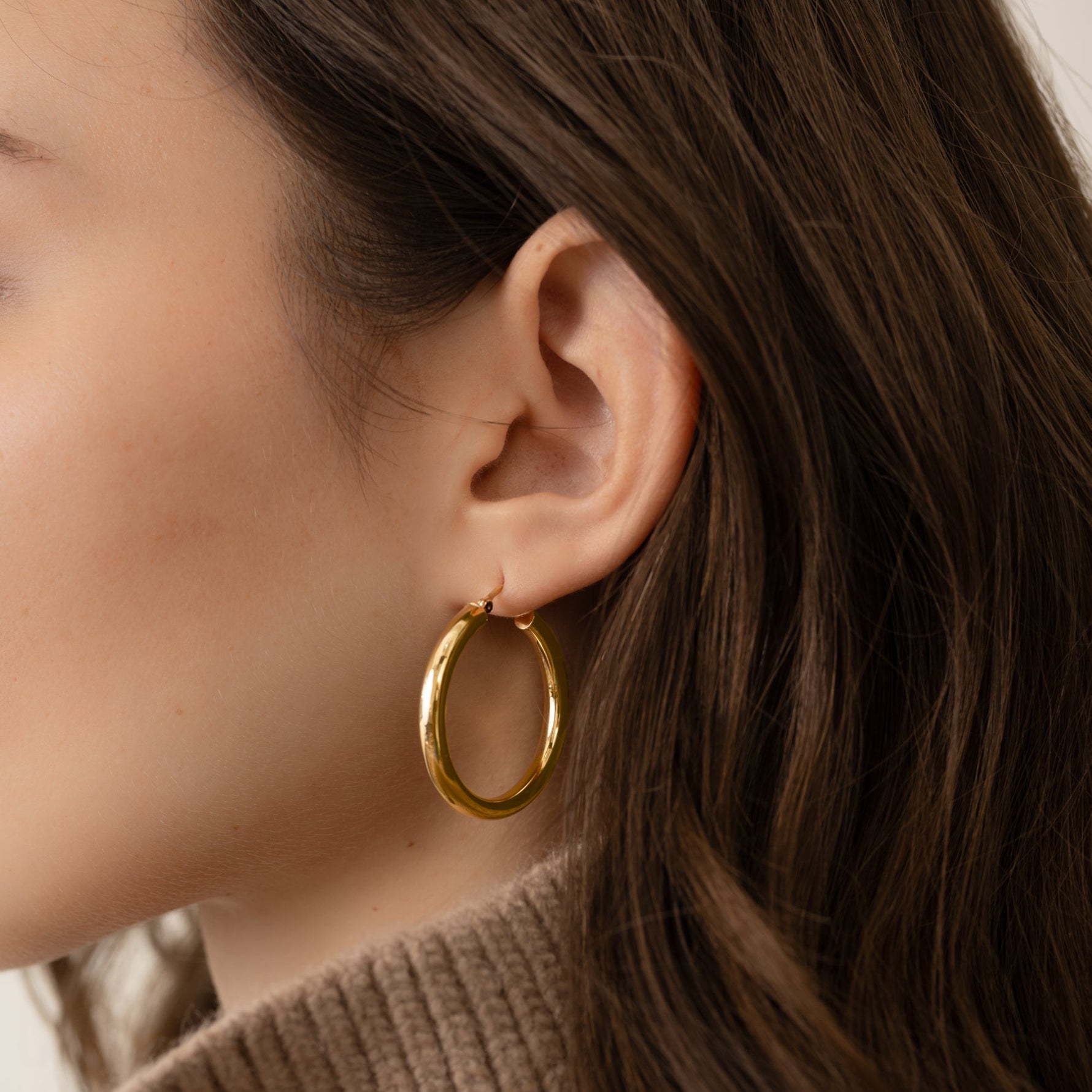 Model wearing gold big JLo hoops from Sami Jewels