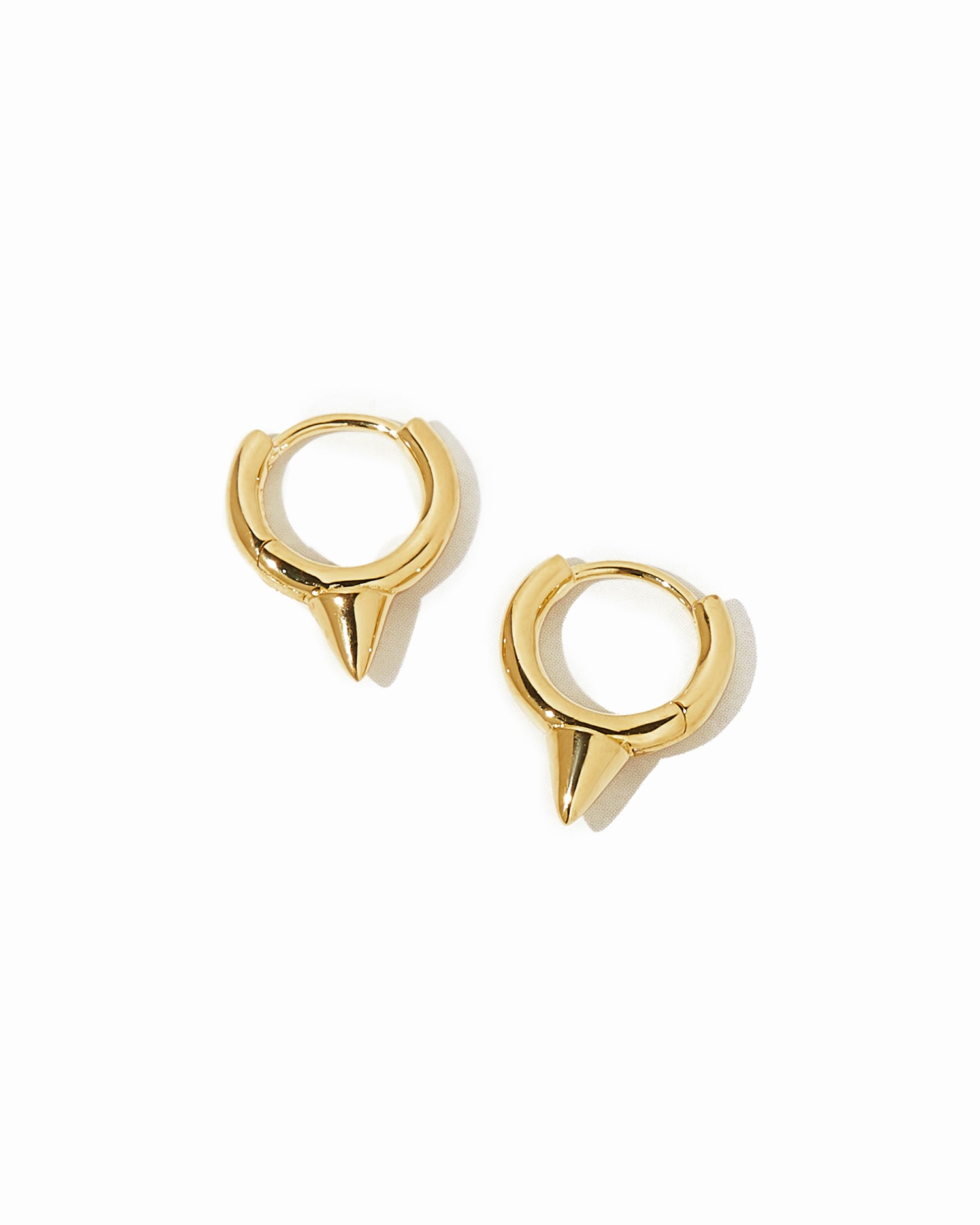 Gold spiked huggie earrings.