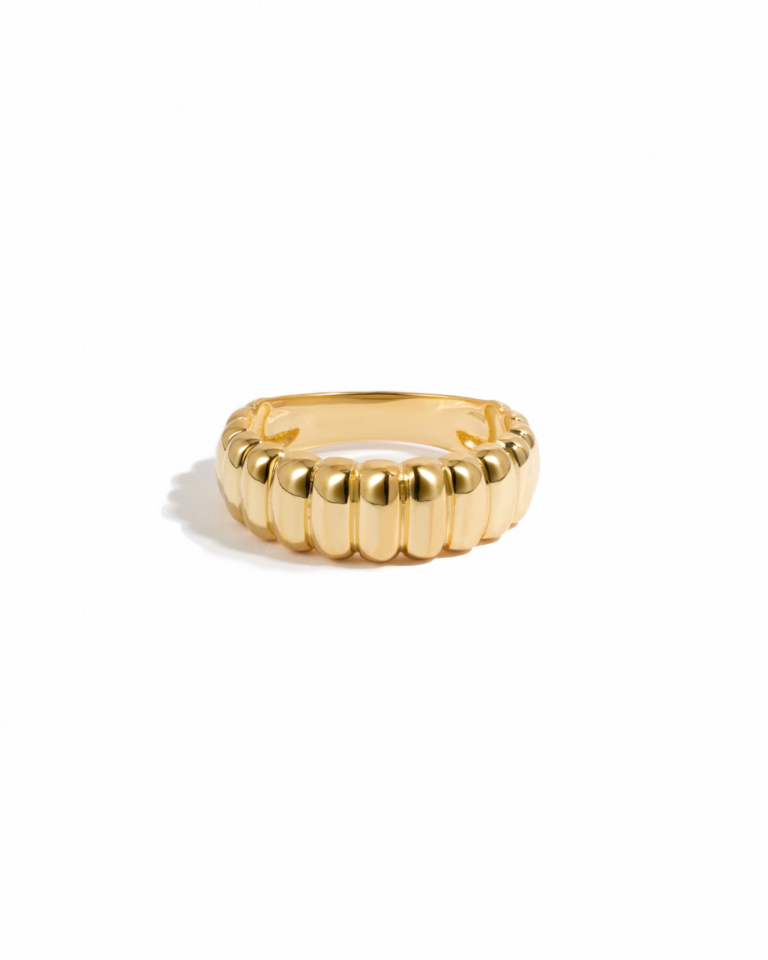 Chunky gold fluted statement ring on a white background.