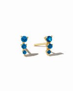 Gold ear climber studs with aquamarine stones.