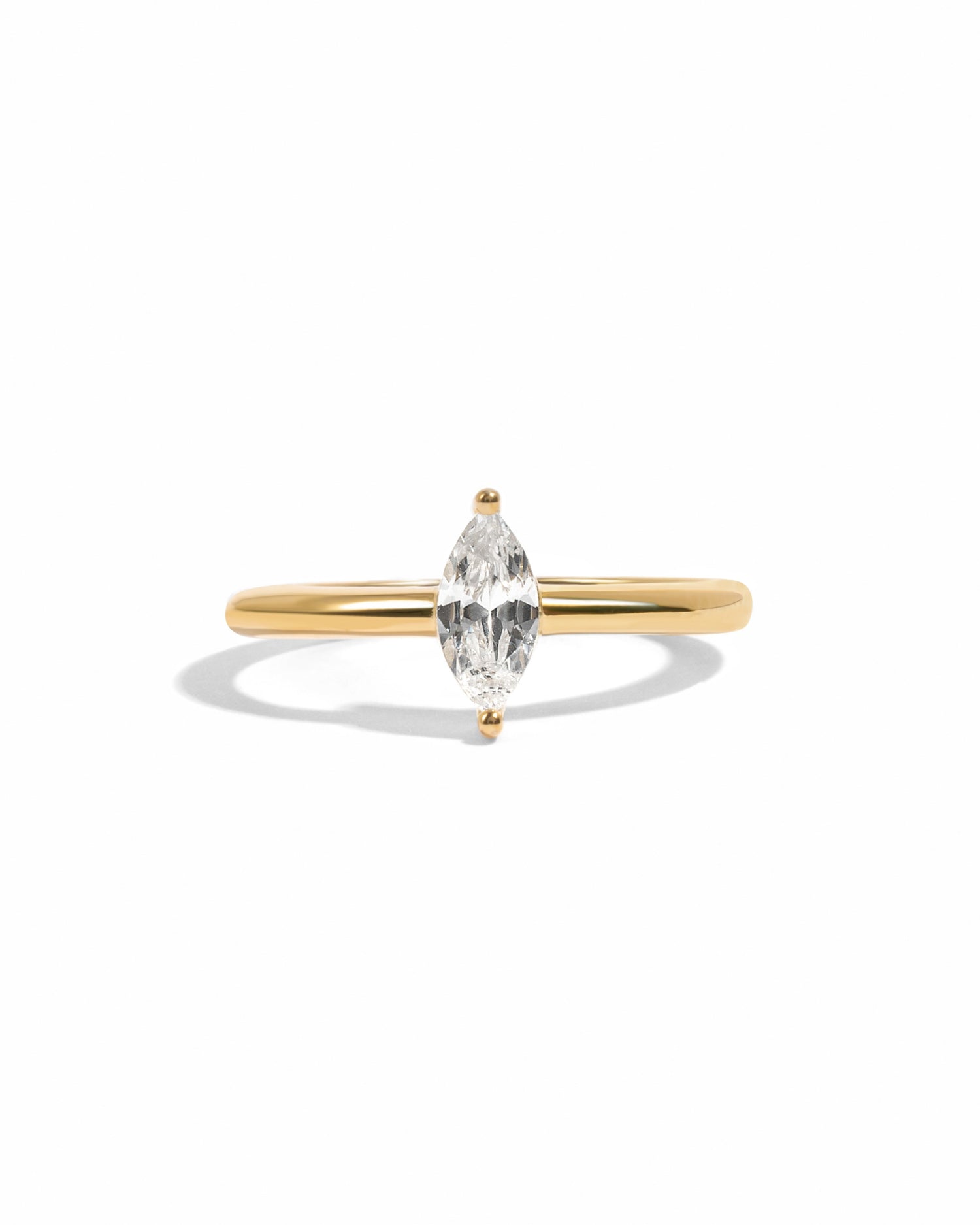Gold marquise diamond engagement ring on a white background.