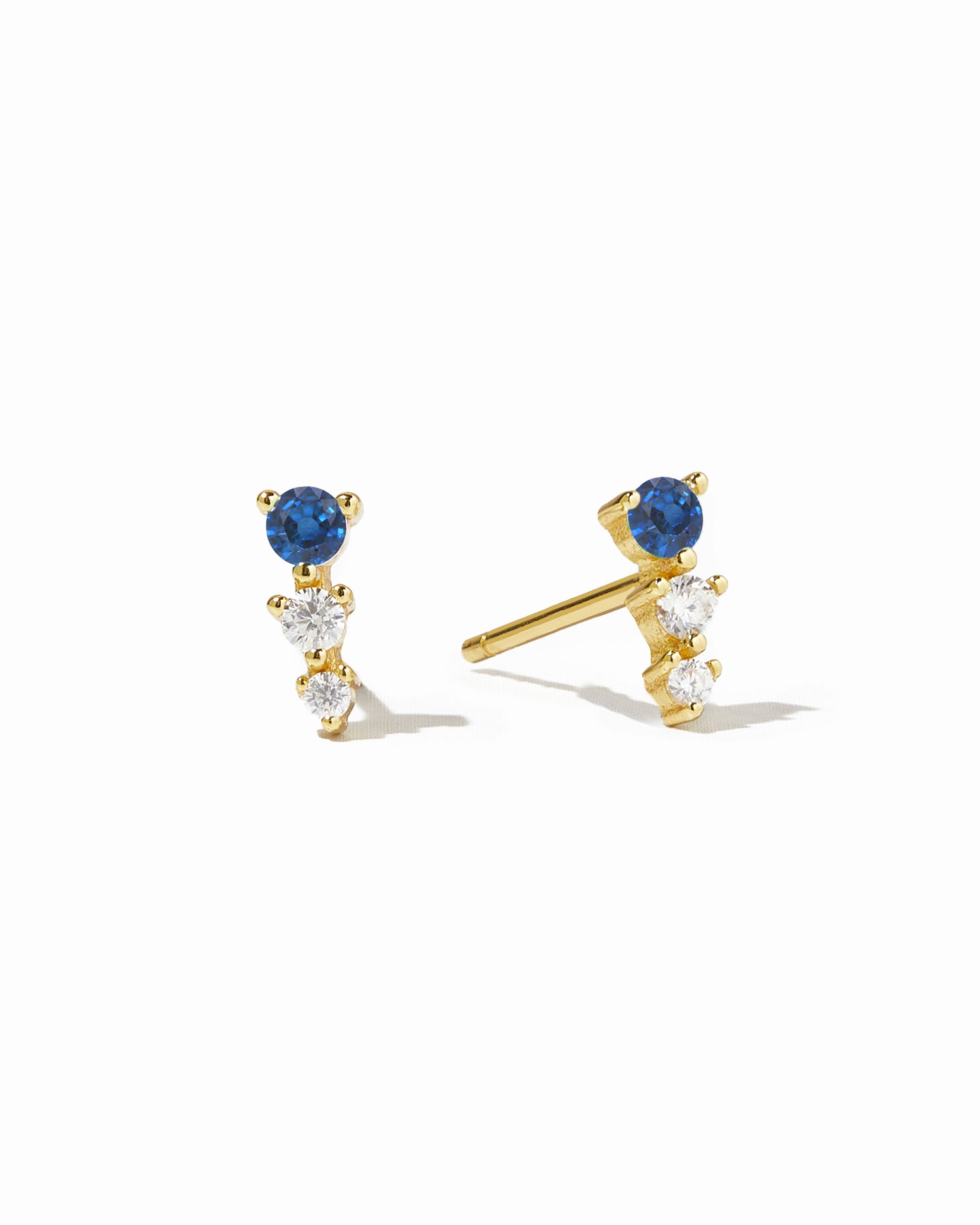 Gold ear climber studs with sapphire and diamond stones.
