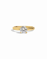 Gold round solitaire diamond engagement ring.