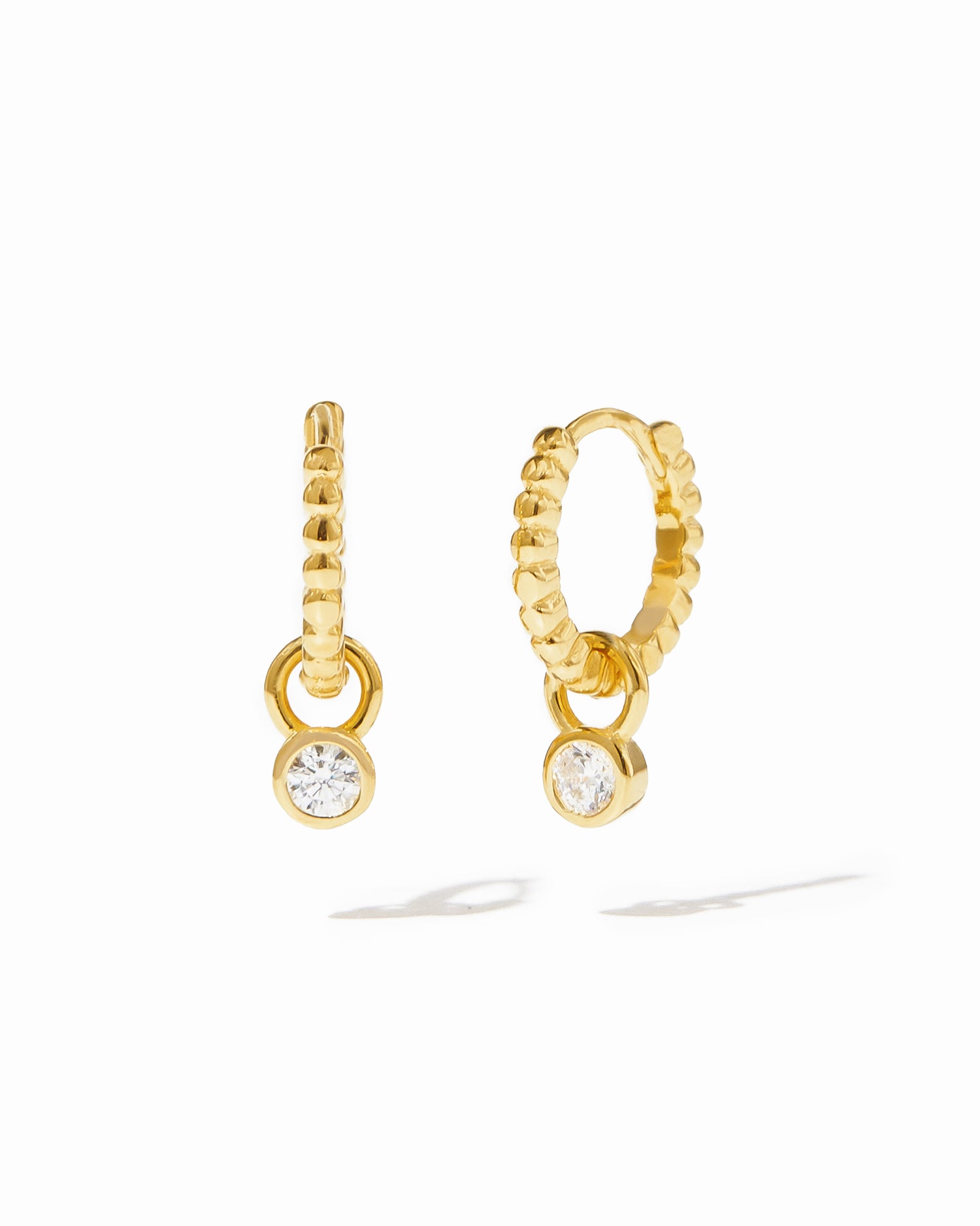 Dainty gold beaded huggies with removable bezel charm. 
