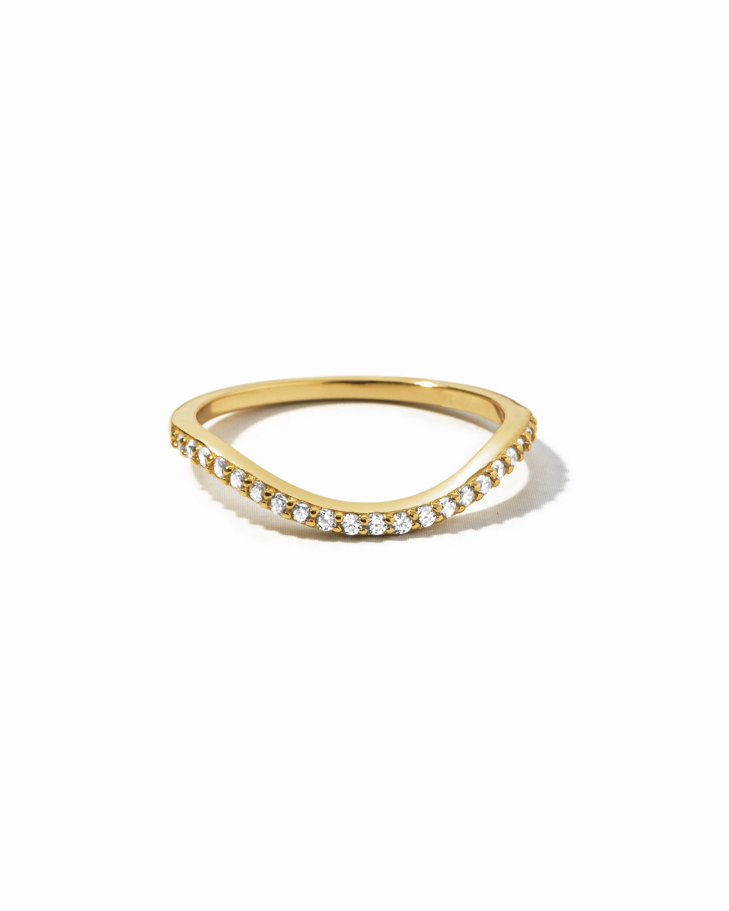 A gold curved band as part of a toi et moi wedding band ring set on a white background
