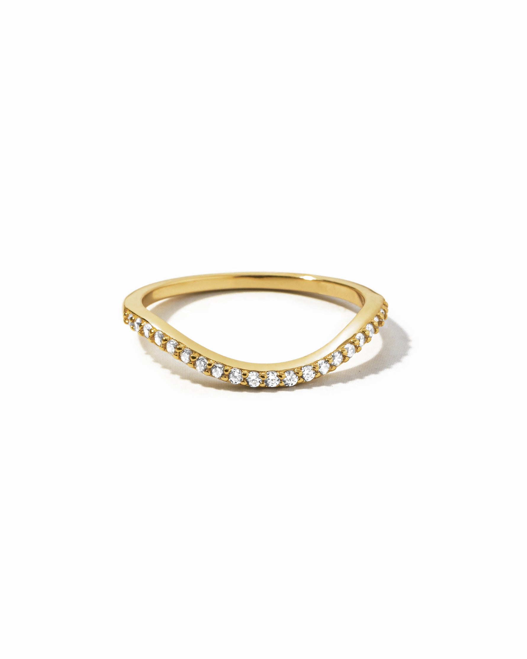 A gold curved band as part of a toi et moi wedding band ring set on a white background