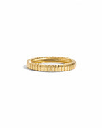 Dainty gold fluted ring on a white background.