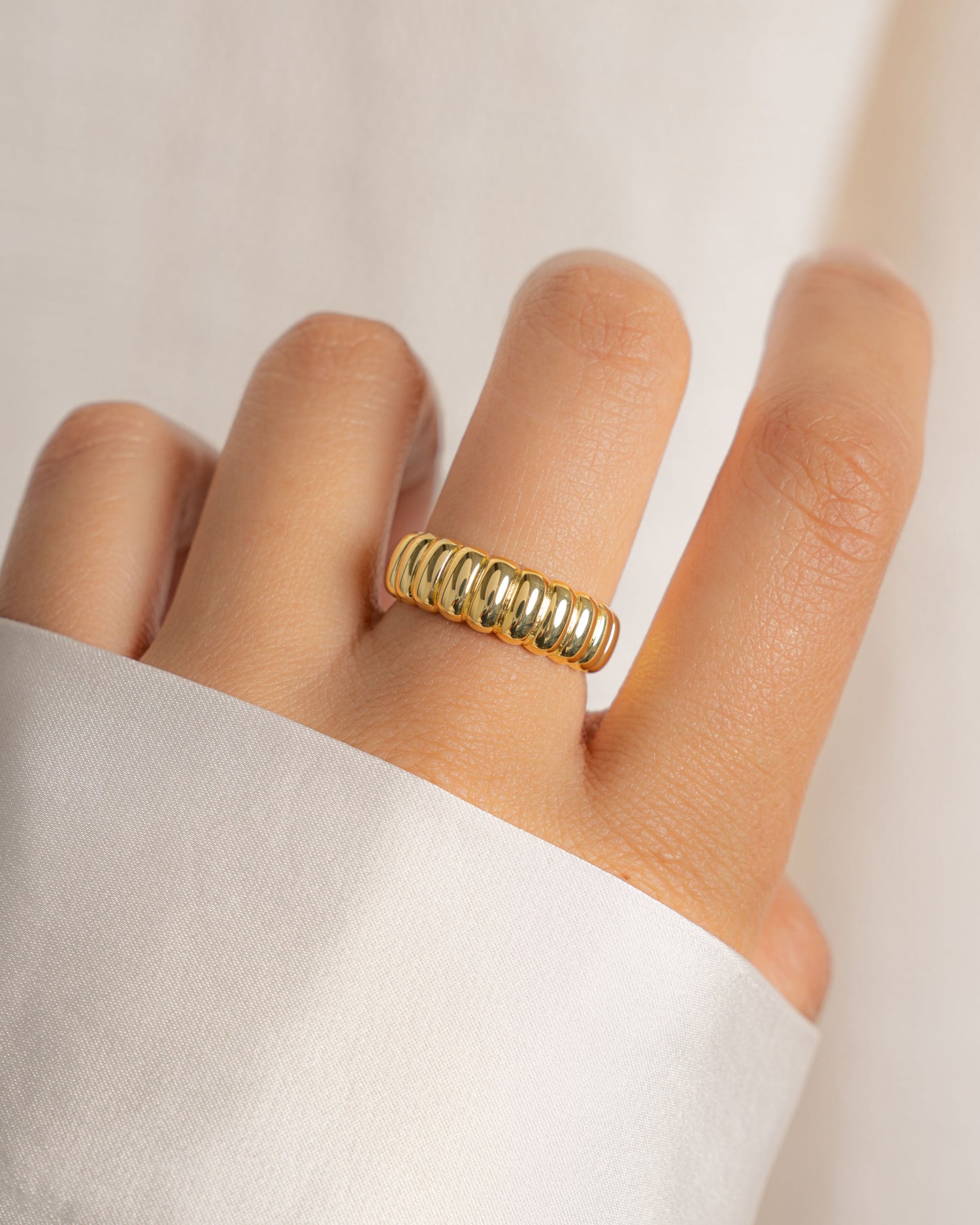 Chunky gold fluted ring on model.