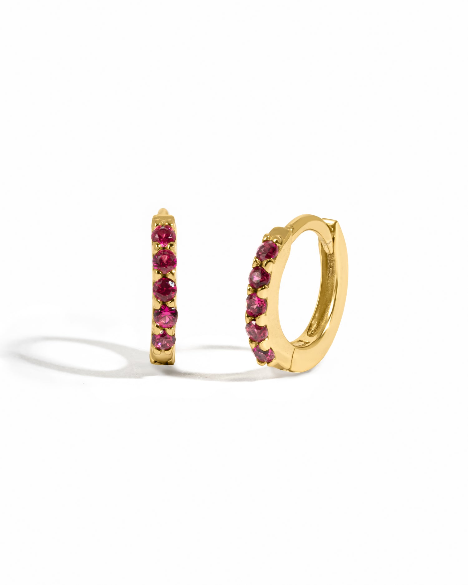 Gold dainty ruby huggie earrings.