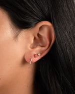 Model wearing ruby birthstone earrings.