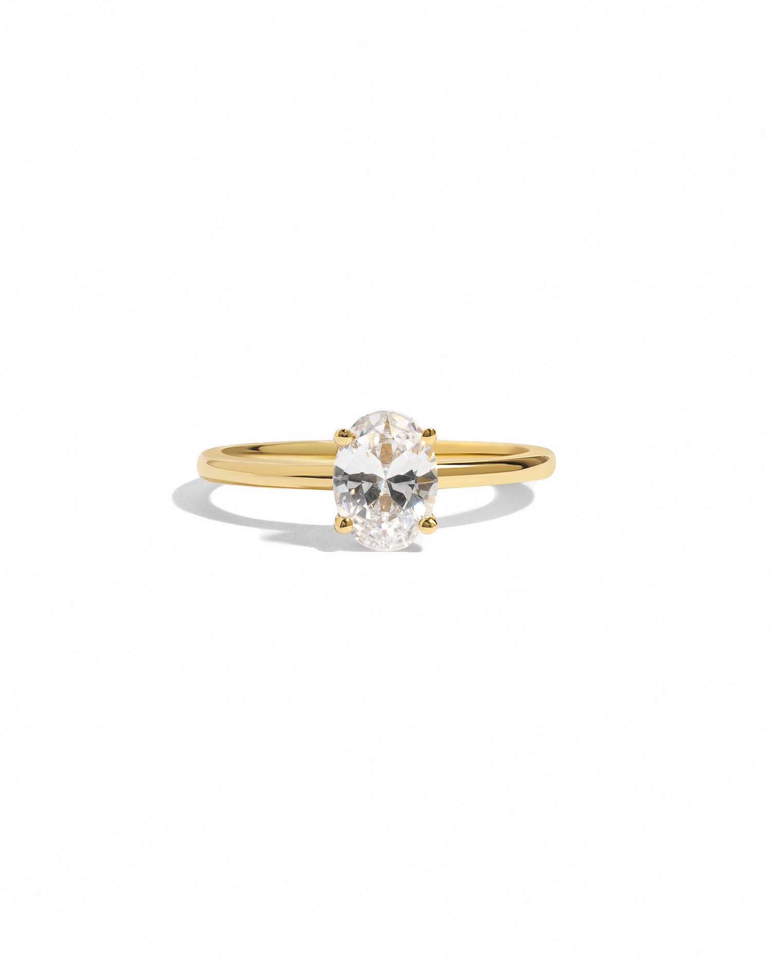Gold solitaire oval diamond engagement ring.