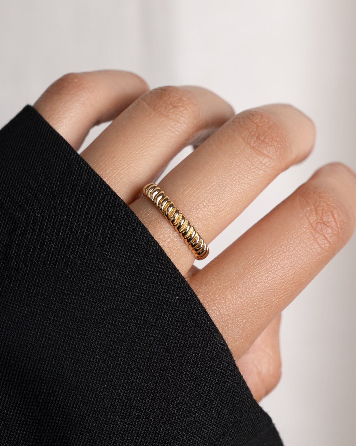 Model wearing gold textured ring. 