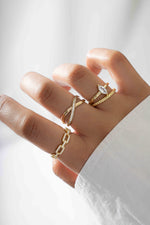 model wearing multiple gold and diamond stacking rings.