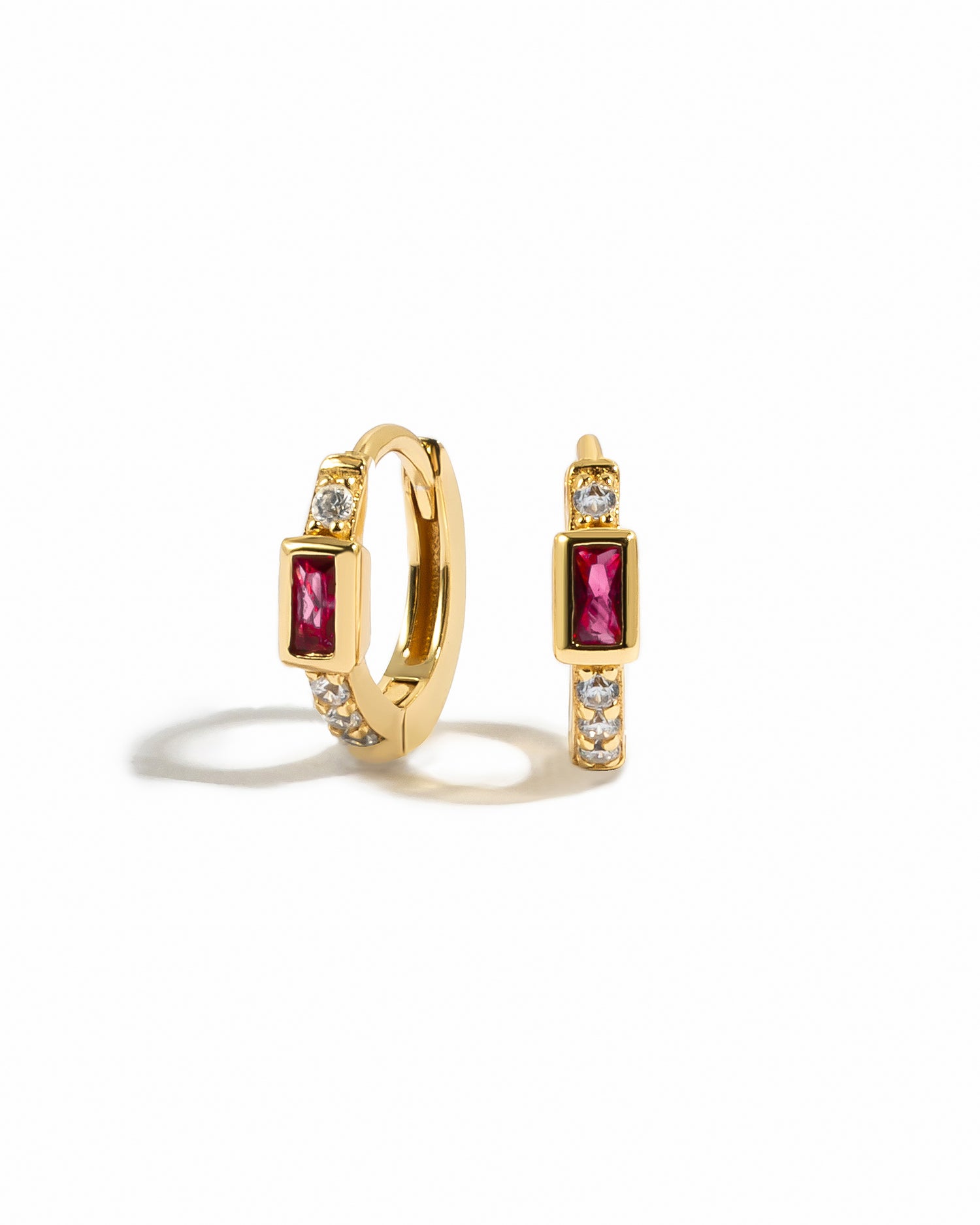 Gold diamond huggie earrings with ruby baguette.