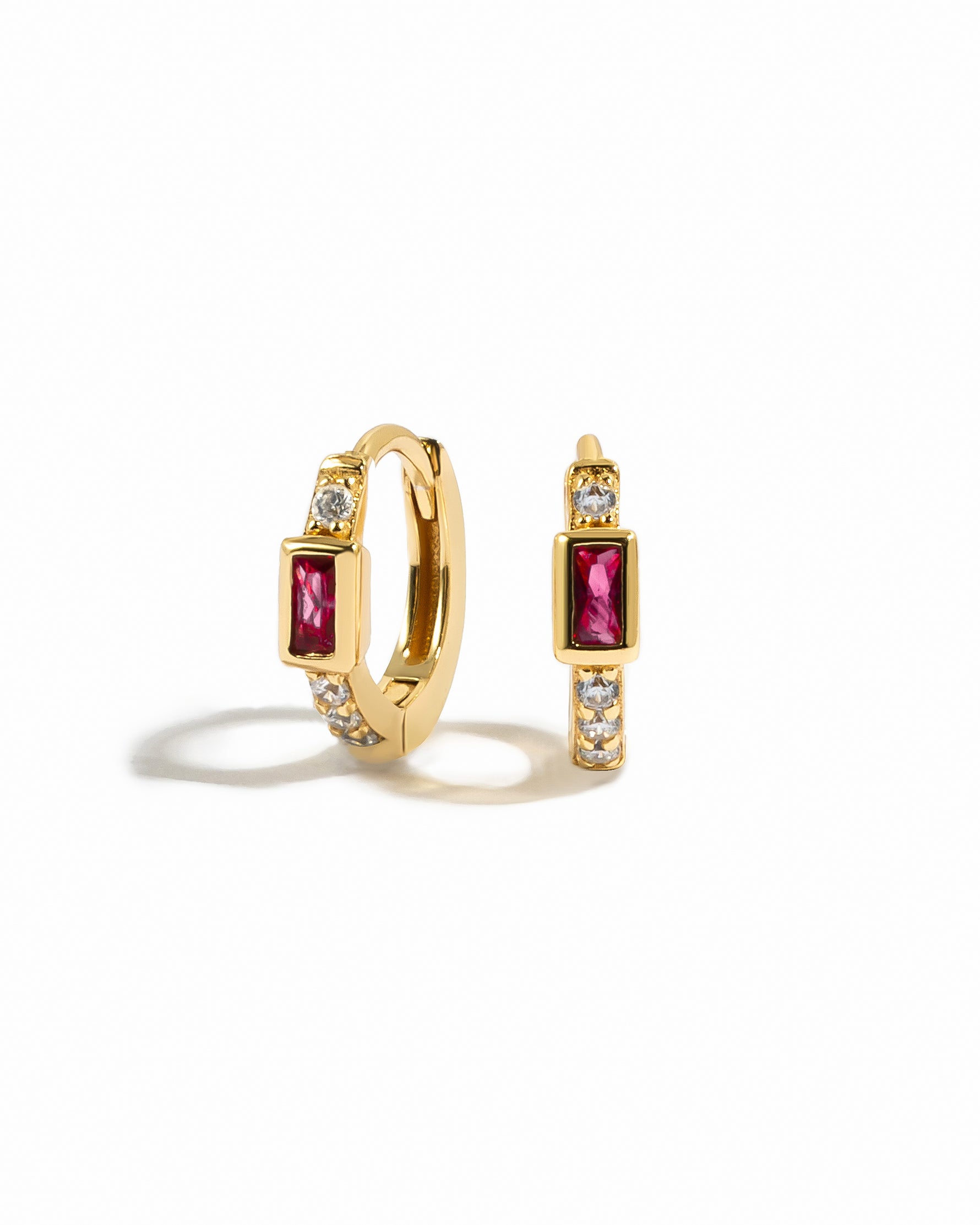 Gold diamond huggie earrings with ruby baguette.