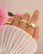 Gold chunky ring stacked with minimalist gold rings,