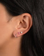 Model wearing sterling silver earrings with ruby birthstones.