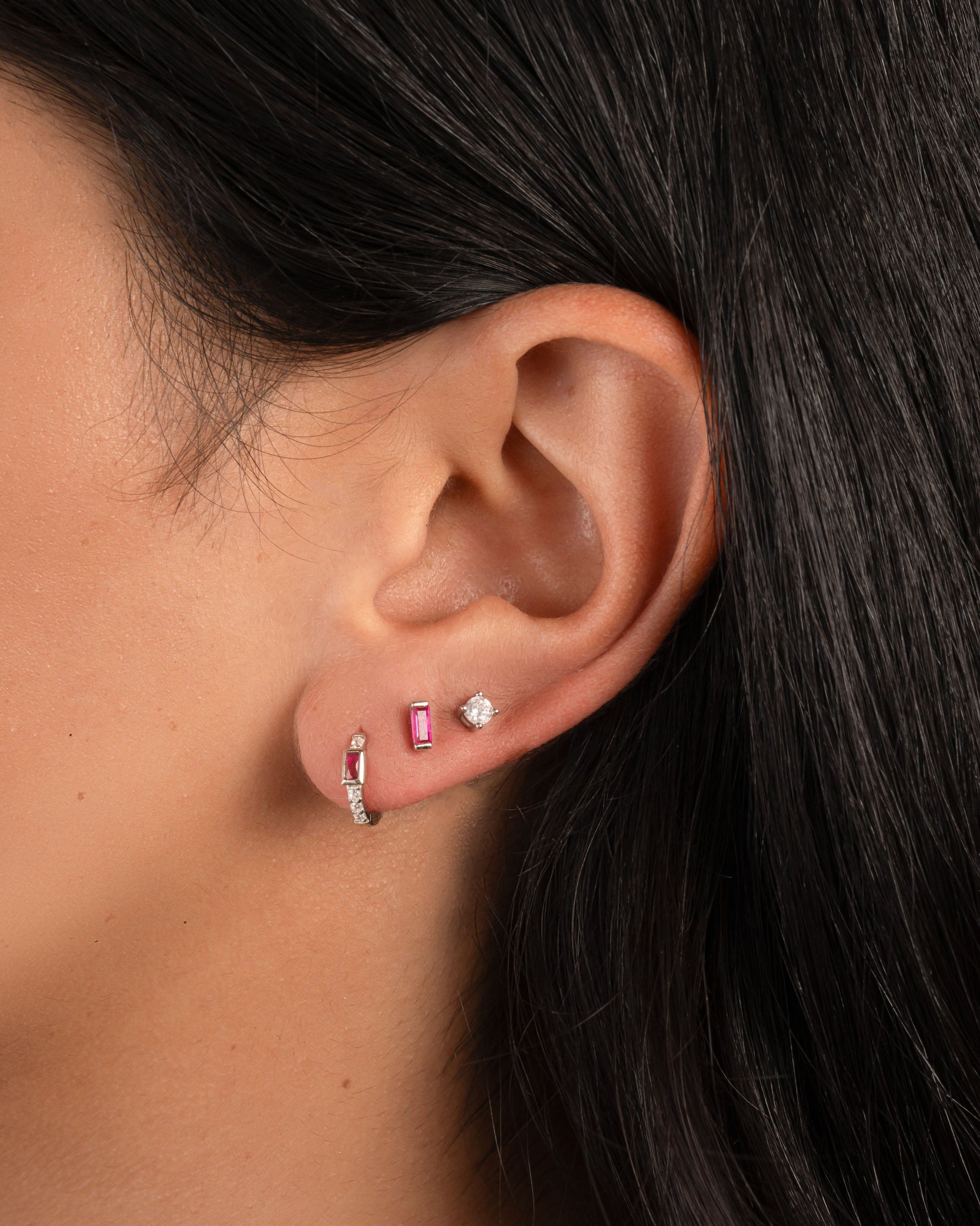 Model wearing sterling silver earrings with ruby birthstones.