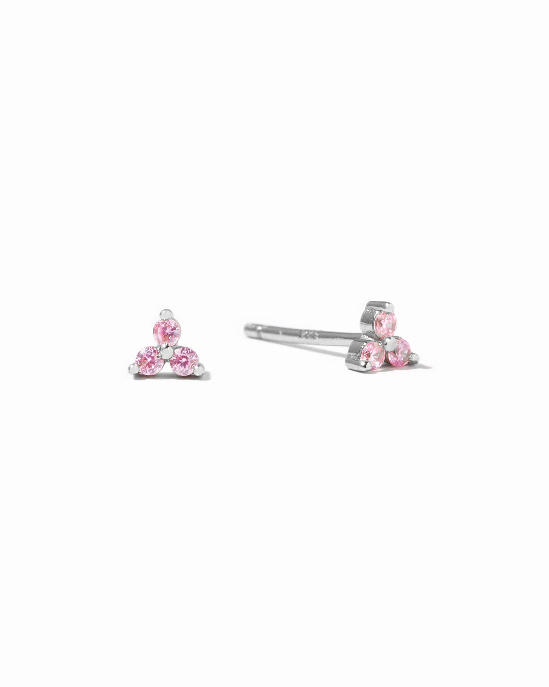 Tiny sterling silver stud earrings with pink gemstones.