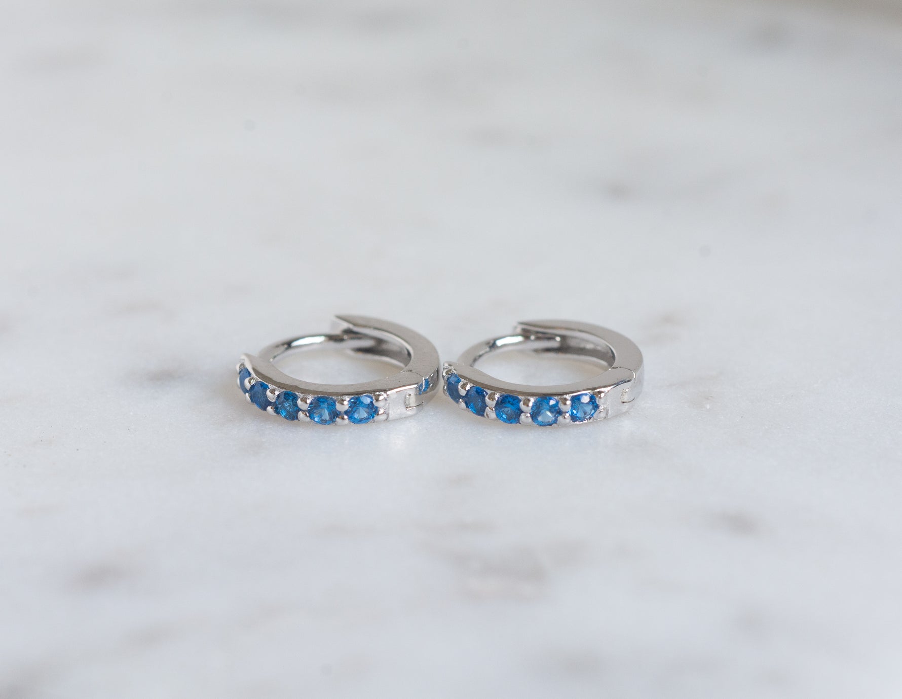 Dainty silver sapphire gemstone huggie hoops.