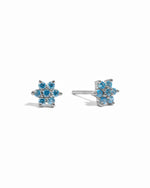 Sterling silver aquamarine birthstone flower studs on white background.