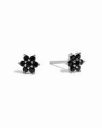 Sterling silver delicate black onyx gemstone flower stud earrings on white background.