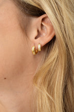 Model wearing gold diamond hoop earring stack
