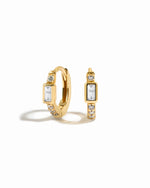 Small gold hoop earrings with cubic zirconia pave stones and a baguette cut stone in the center