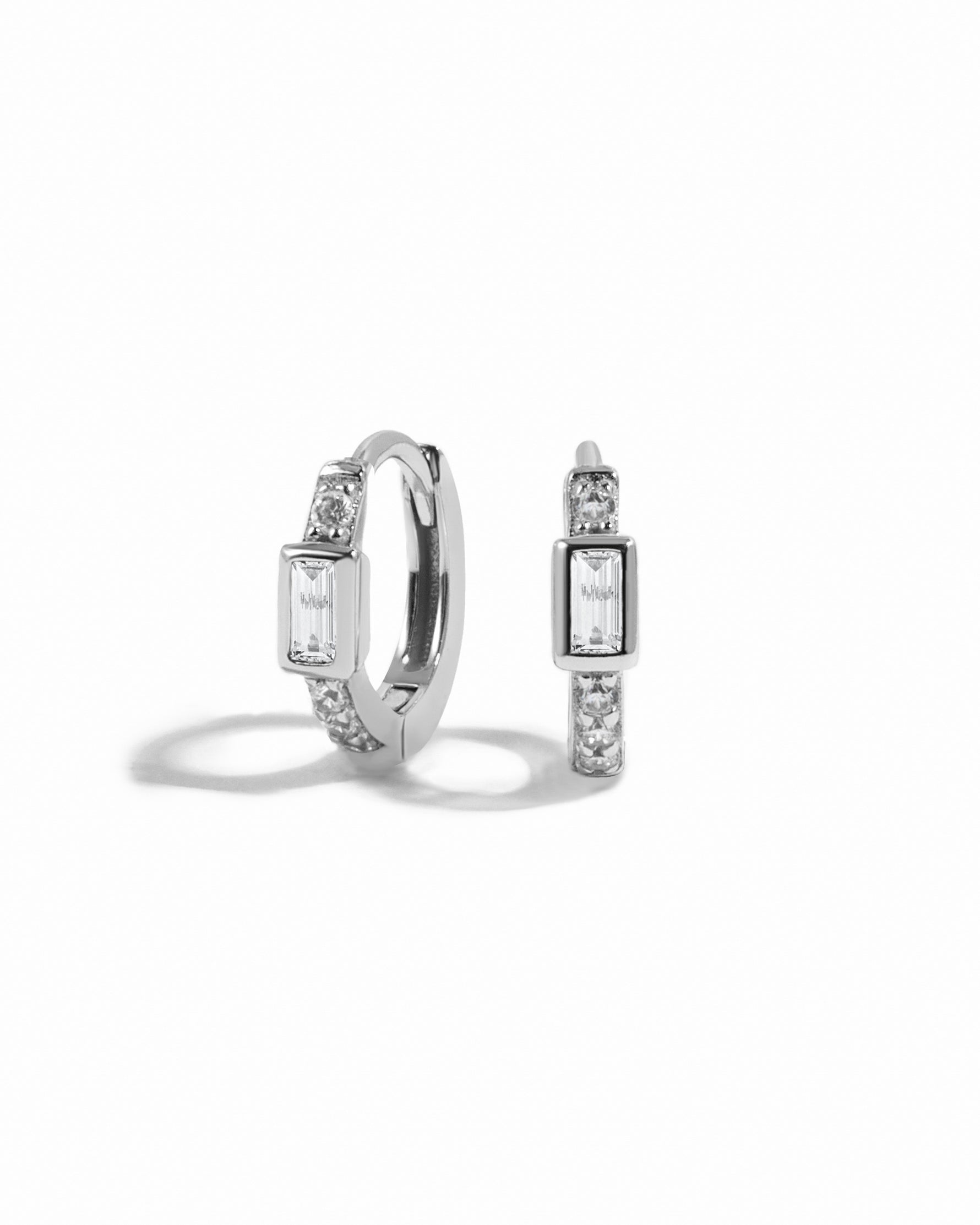 Silver small huggie hoops on a white background