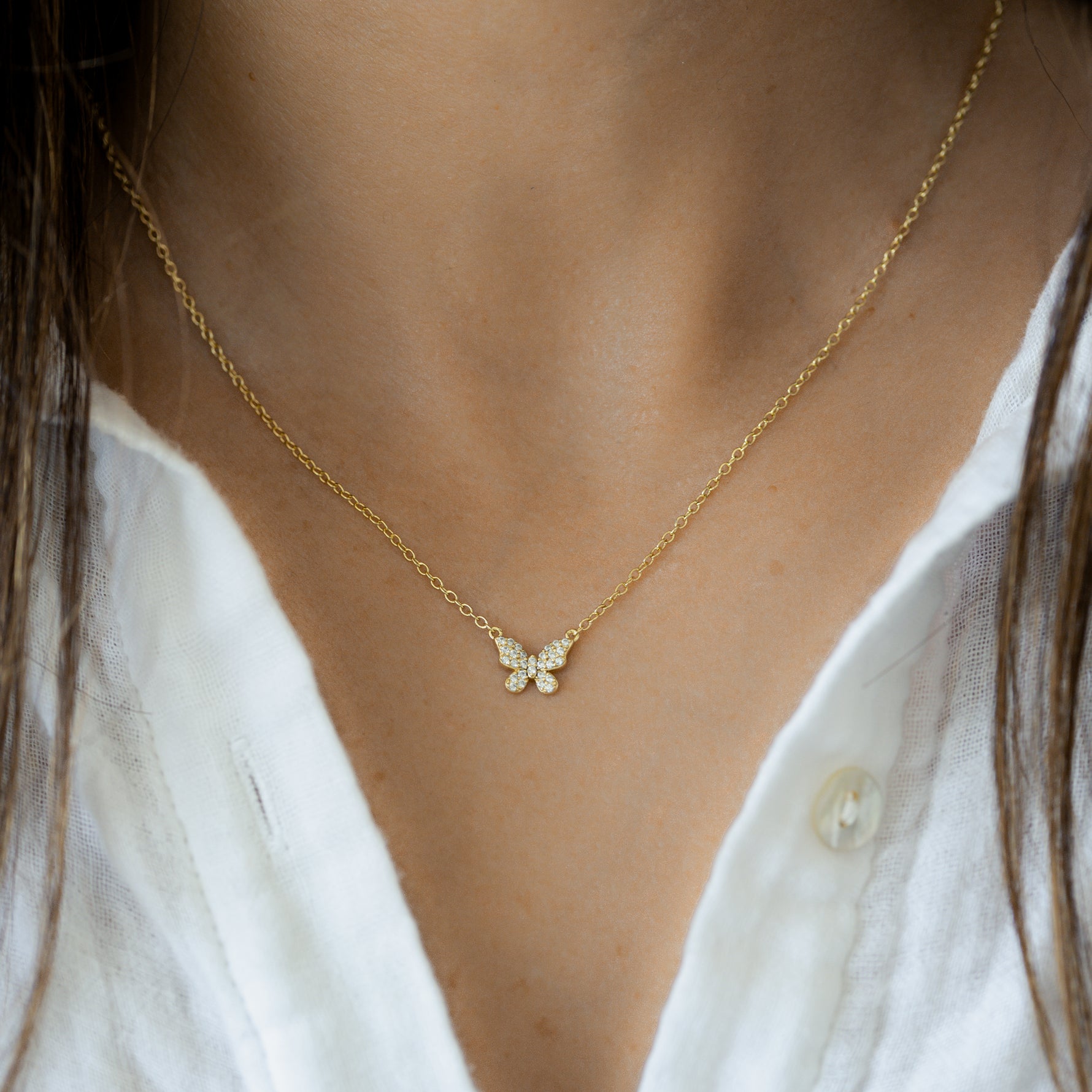 Model wearing minimalist cz butterfly necklace. 