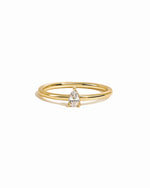 Dainty solitaire pear ring on white background.