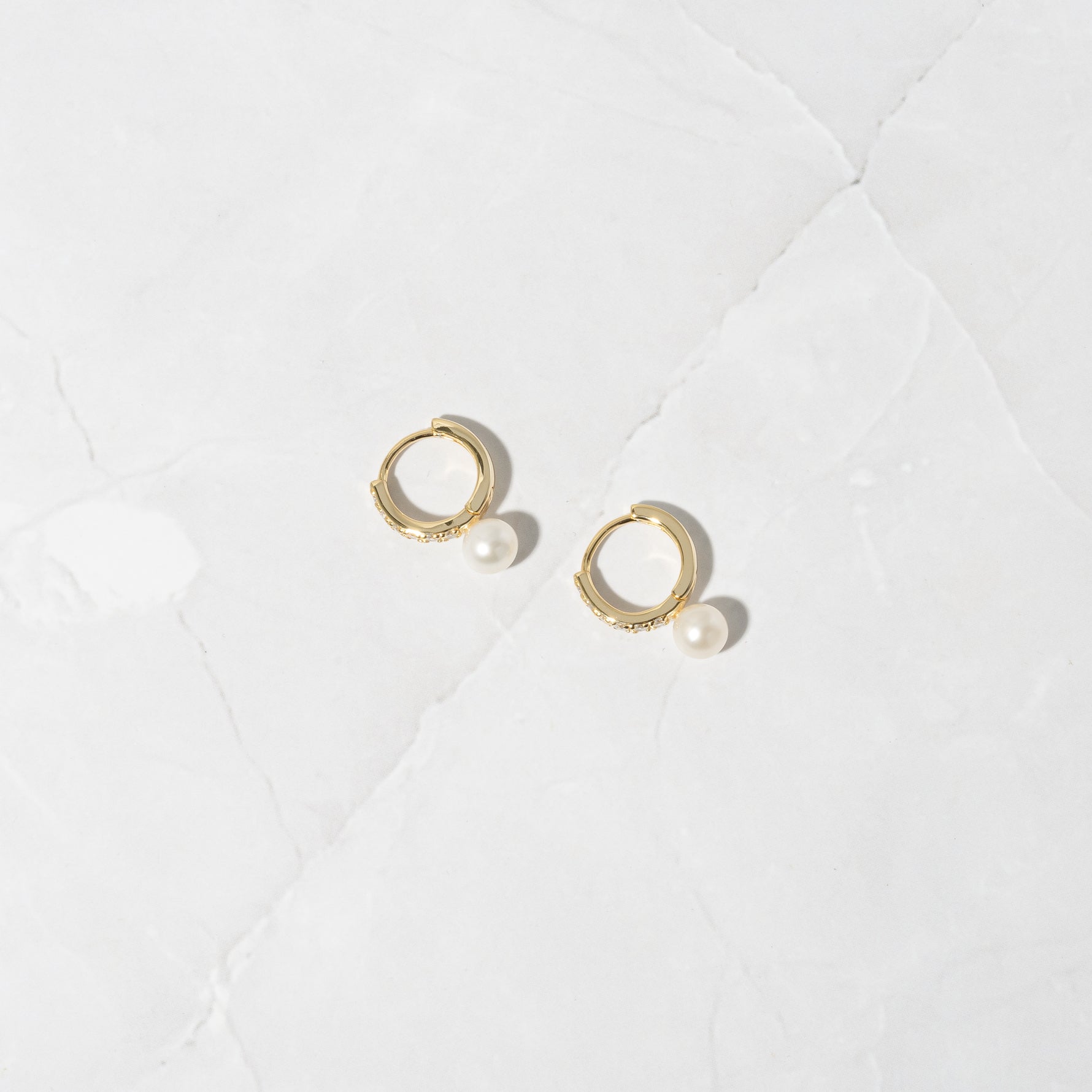 Delicate and feminine gold pearl charm earrings. 