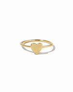 Plain solitaire gold heart ring on white background.
